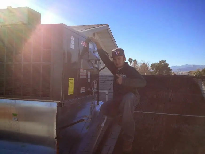 HVAC technician performing AC Tune-Up on a rooftop unit in Rockland